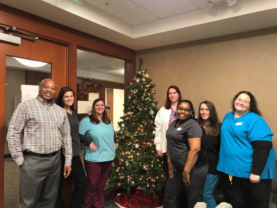 Cary Ortho employees gathered around a Christmas tree