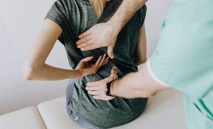 Woman and physical therapist discussing back pain relief
