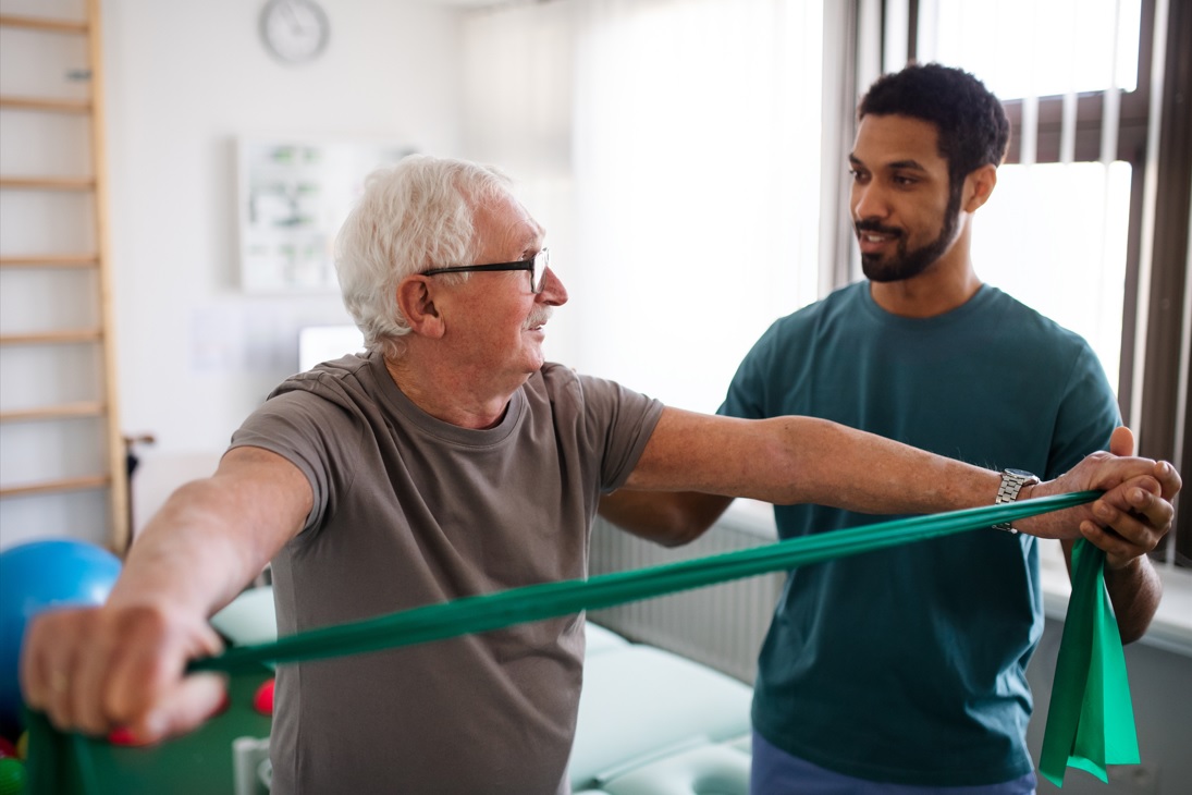 physical therapist leading patient through therapeutic exercise