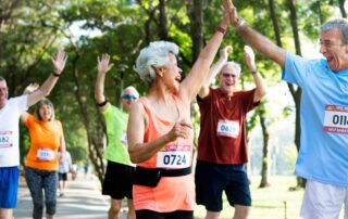 mature couple high fiving after running a race. Tips for the aging athlete