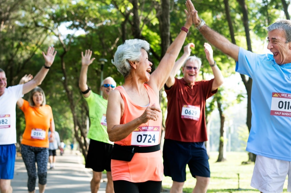 mature couple high fiving after running a race. Tips for the aging athlete