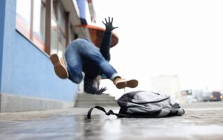 man with backpack falling in need of slip and fall prevention tips