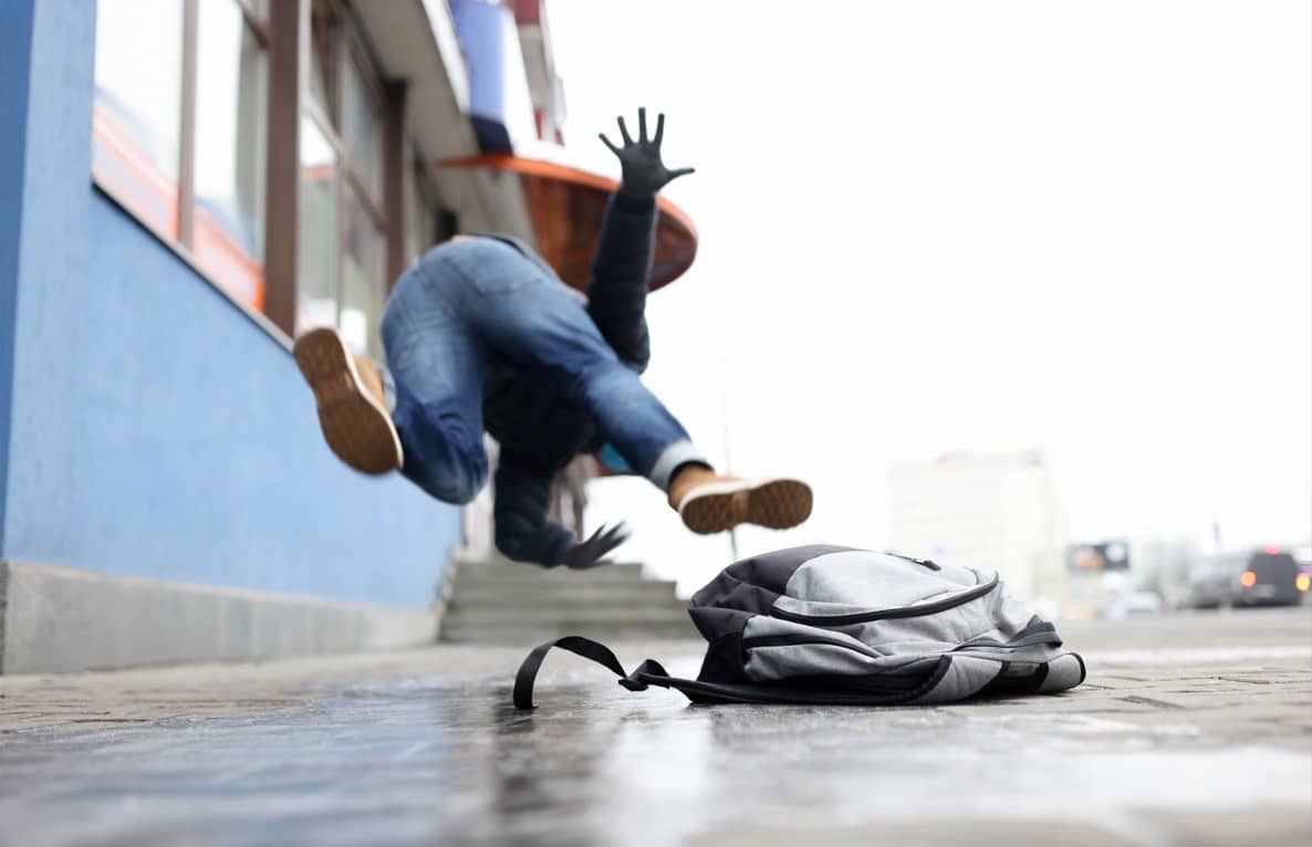 man with backpack falling in need of slip and fall prevention tips