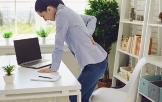 woman with sciatic nerve pain holding her back