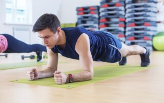 man holding forearm plank demonstrating cross training for athletes