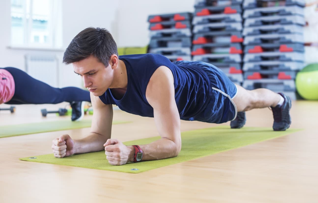 man holding forearm plank demonstrating cross training for athletes