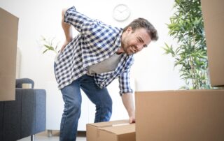 man lifting a heavy box, needs good lifting habits to keep joints health