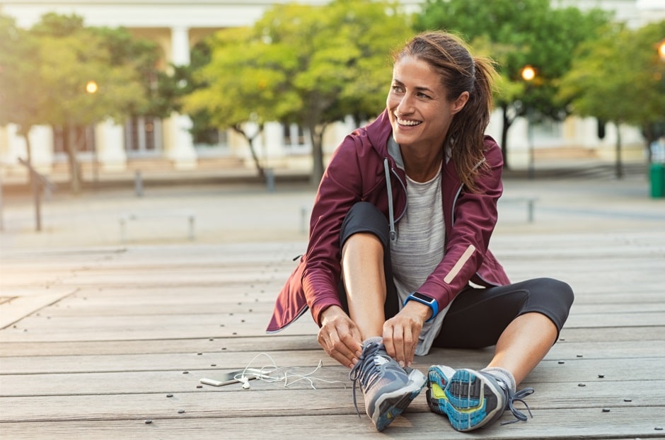 woman tying shoes getting into running form