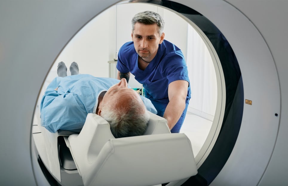 orthopedic imaging technician moving patient into CT scan machine