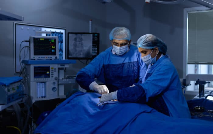 Surgeons performing surgery on a patient with a bulging disc at the hospital.